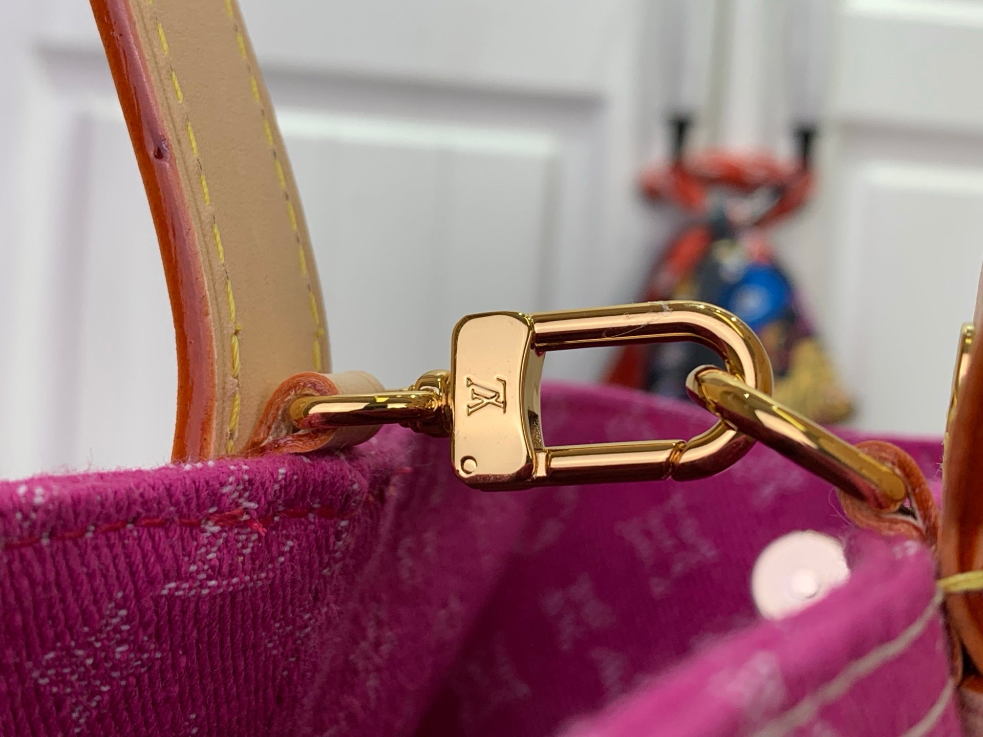 Magenta monogram tote with gold-tone D-ring clasp and tan shoulder strap