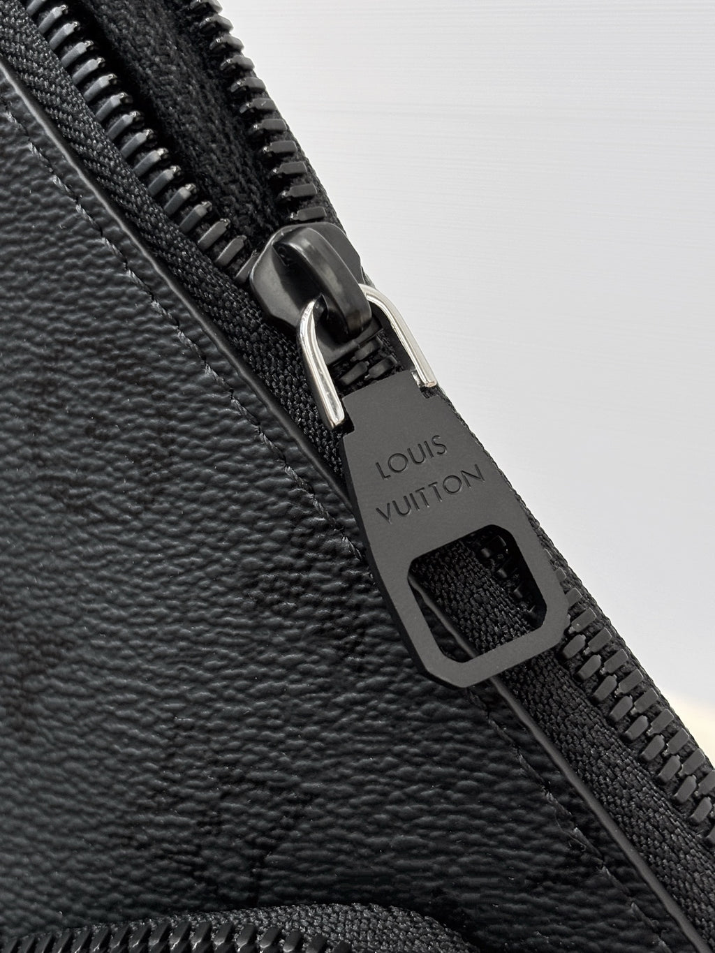 Louis Vuitton black zipper pull with engraved logo on monogram bag
