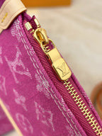 Gold zipper pull and hardware on purple monogram bag edge