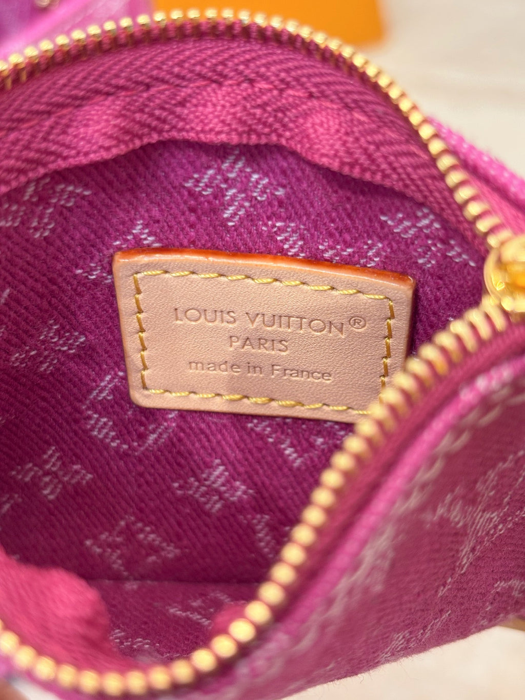 Inside patch label with gold zipper and stitched monogram fabric