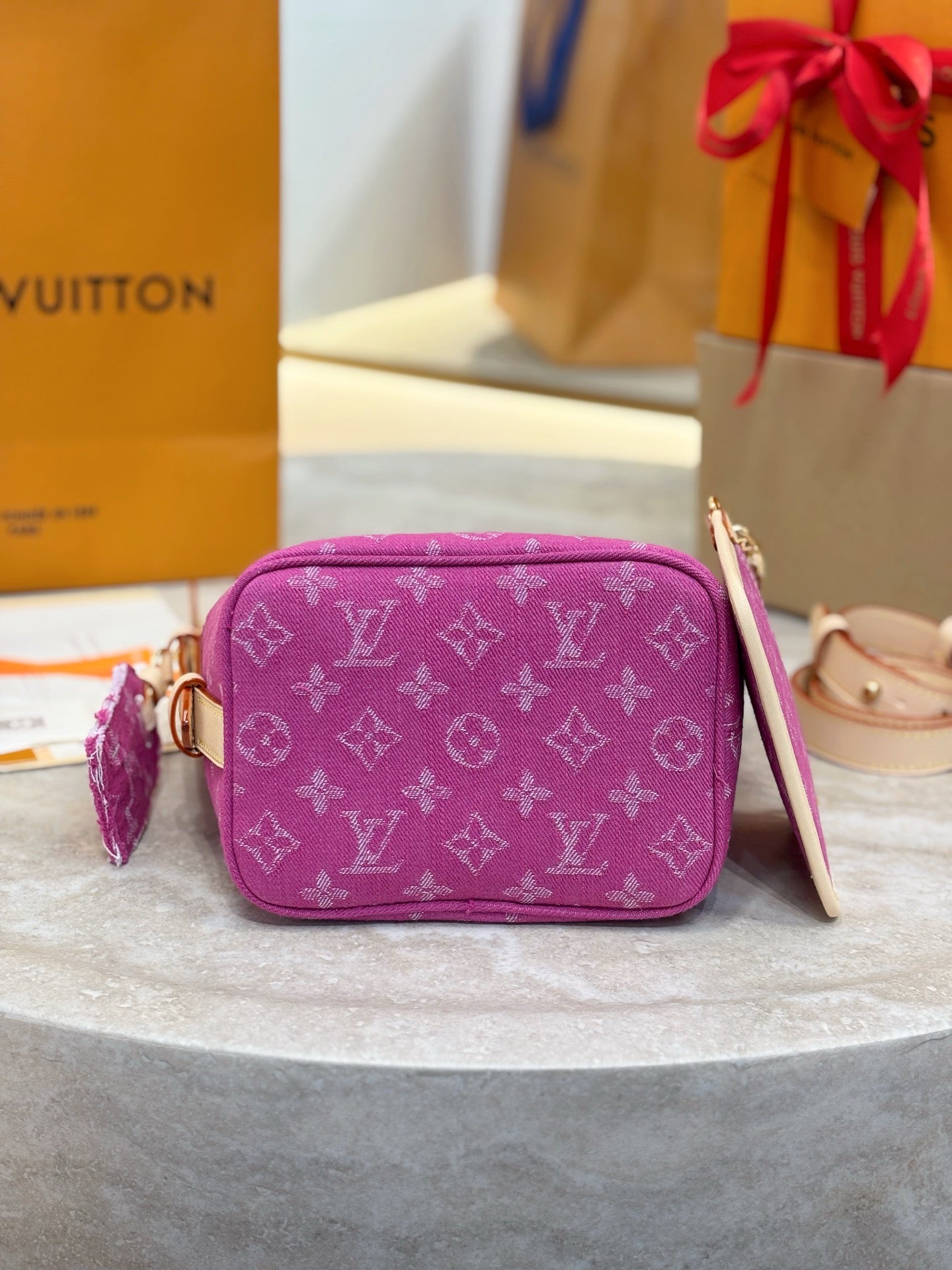 Purple monogram crossbody bag with top handle and side tassel detail