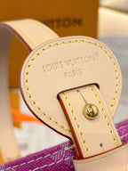 Leather logo tab with gold stud on purple monogram bag