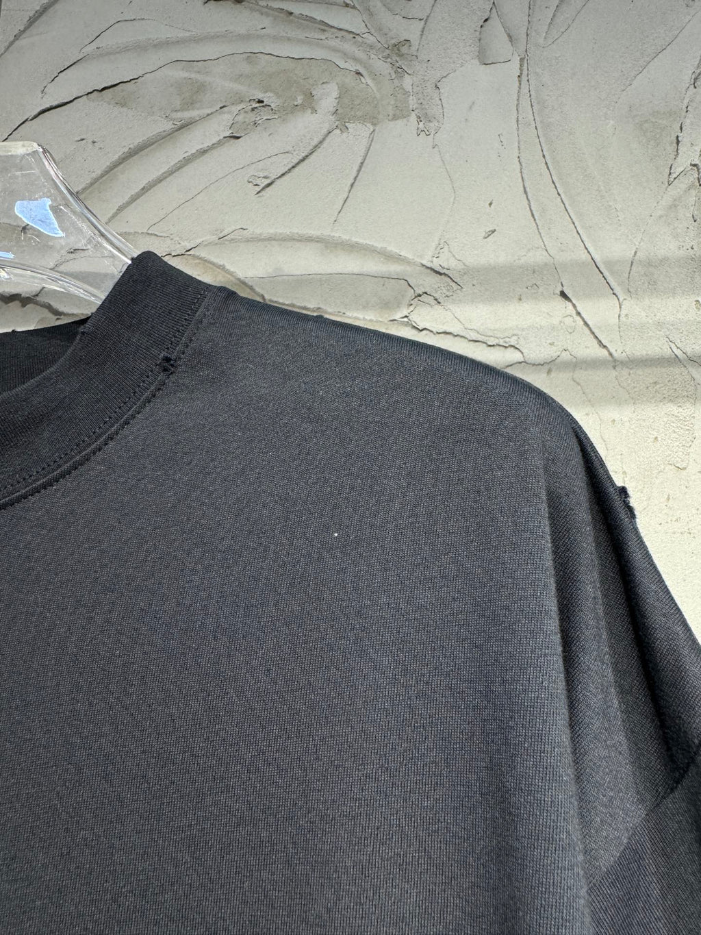 Black crewneck T-shirt, plain chest with visible shoulder seam and drape