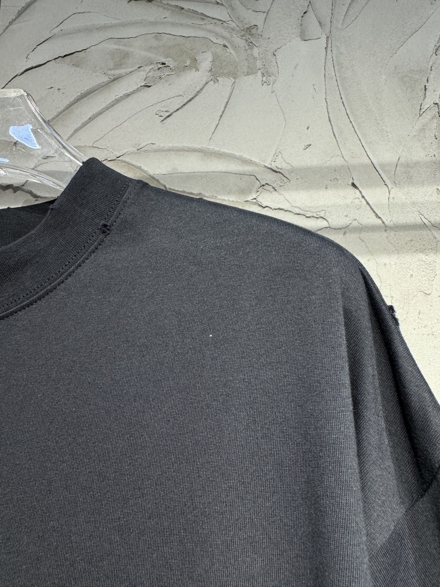 Black crewneck T-shirt, plain chest with visible shoulder seam and drape