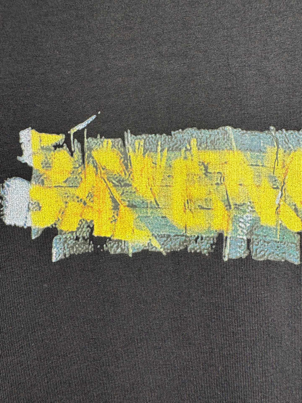 Black crewneck T-shirt with close-up yellow, blue, and aqua paint-style graphic print