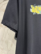 Black crewneck T-shirt with short sleeve cuff and yellow graphic on chest