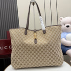 Gucci GG canvas tote bag with dark leather trim and gold hardware, dual top handles