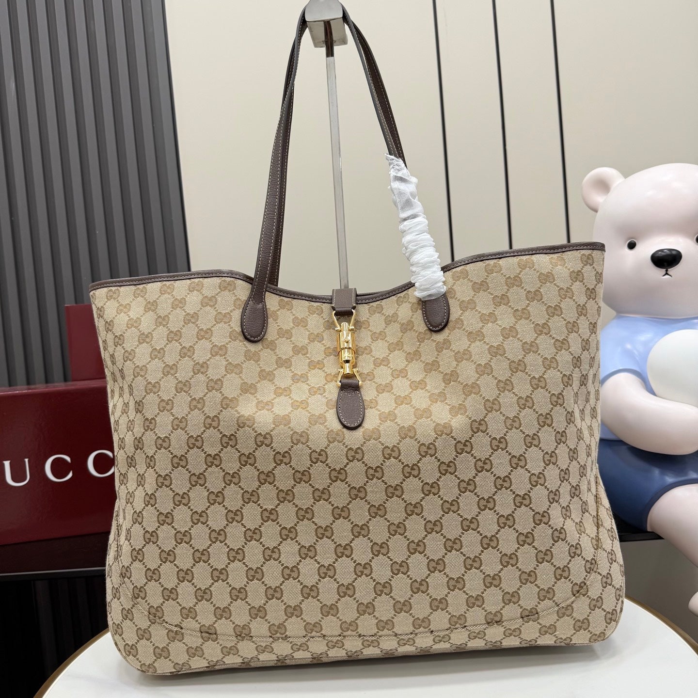 Gucci GG canvas tote bag with dark leather trim and gold hardware, dual top handles