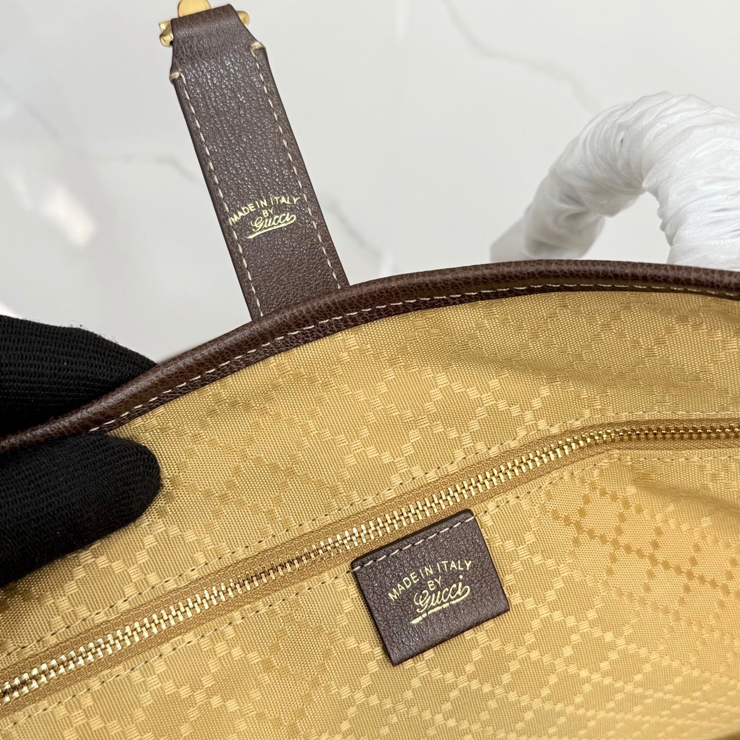 Gucci tote bag interior close-up of Made in Italy label and gold zipper