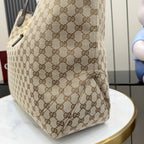 Gucci GG canvas tote bag side panel with logo pattern and dark leather trim