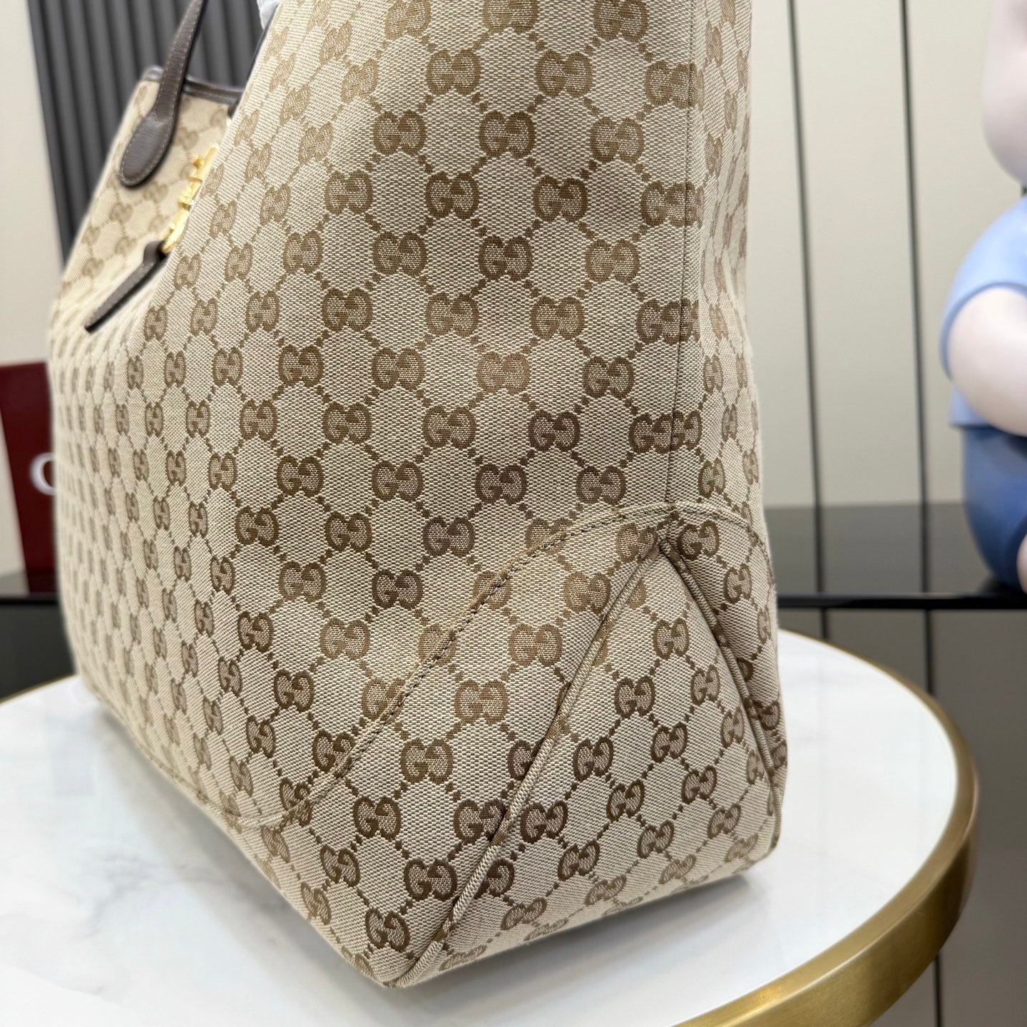 Gucci GG canvas tote bag side panel with logo pattern and dark leather trim
