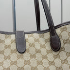 Gucci GG canvas tote bag close-up of dark leather handle tabs and stitching