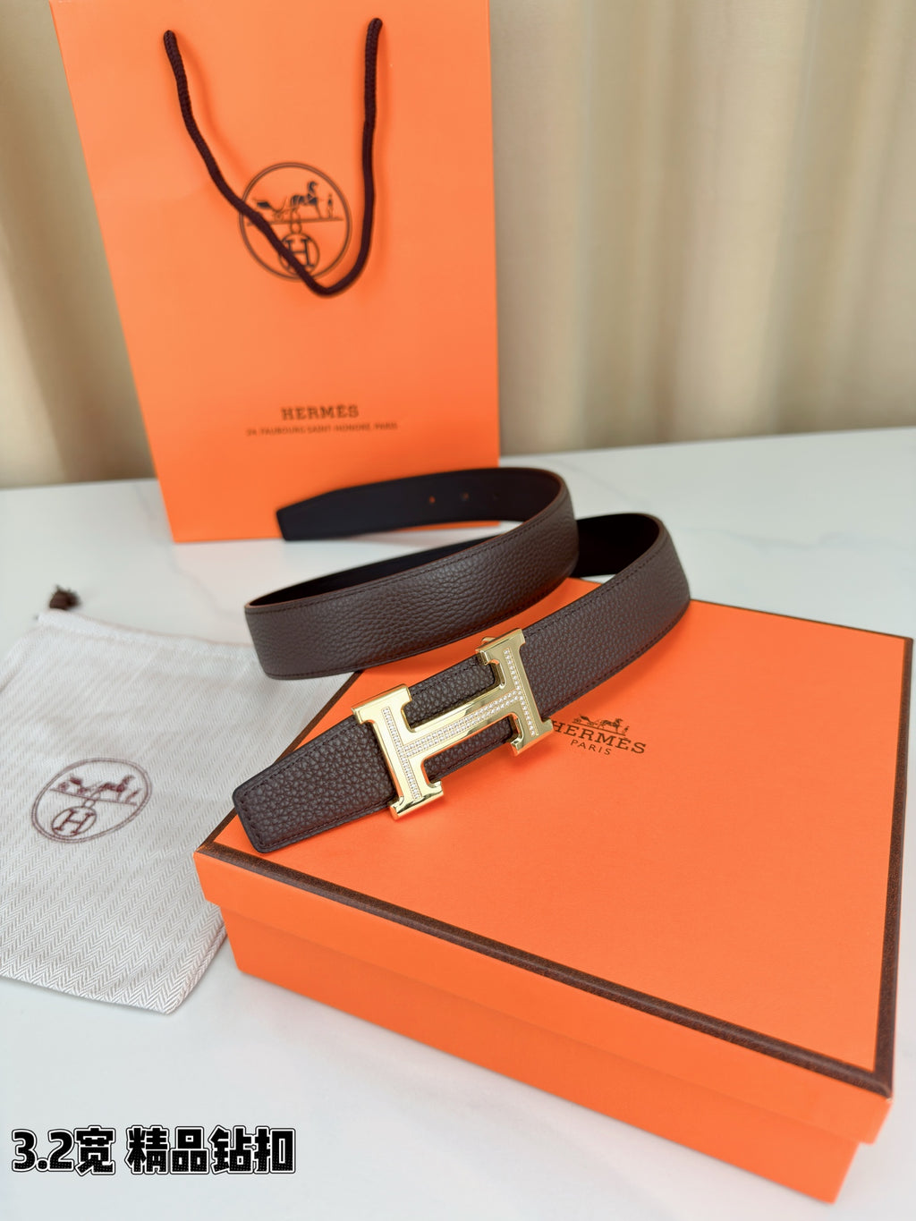 Dark brown leather belt with H buckle and gold-tone accents on strap