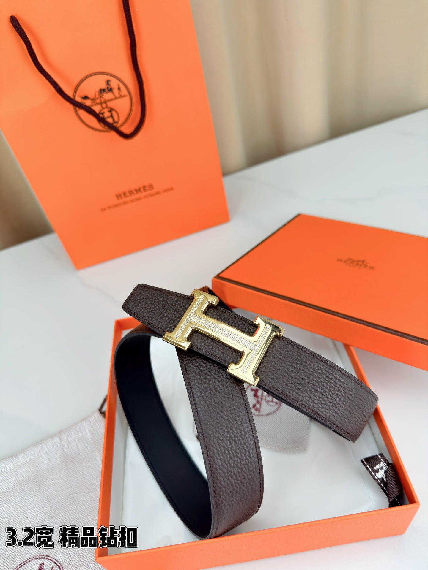 Dark brown leather belt with H buckle on orange presentation box