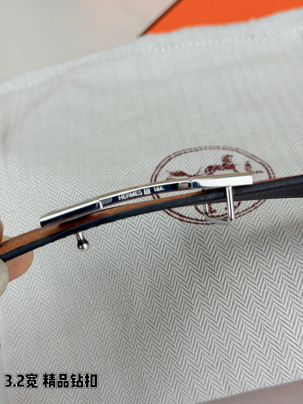 Leather belt with tan strap and silver bar buckle, holes on dark strap