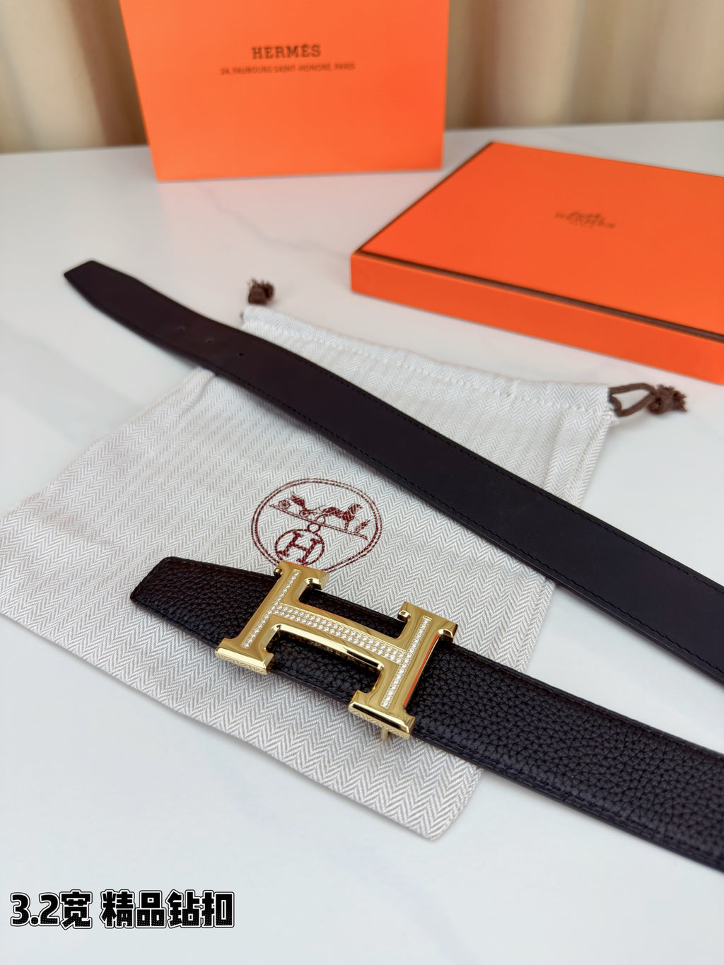 Hermes belt laid flat: dark leather strap with gold-tone H buckle