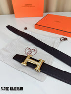 Hermes belt laid flat: dark leather strap with gold-tone H buckle