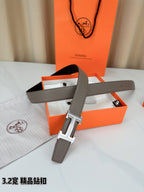 Light gray Hermes belt with silver-tone buckle and long strap laid across box