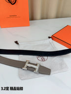 Light gray Hermes belt with silver-tone buckle, styled on white cloth