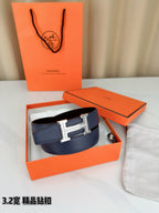 Hermes belt in dark blue leather with silver H buckle, shown in box