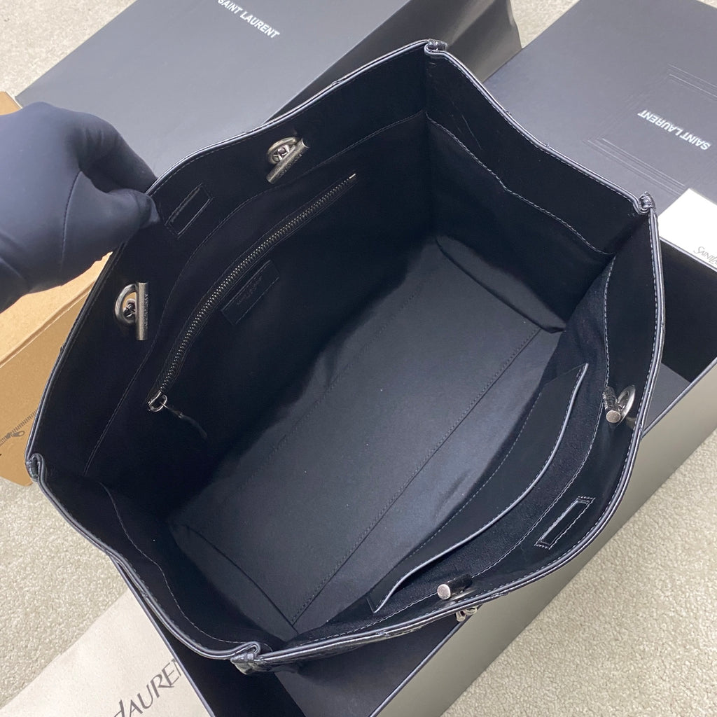 Structured black tote bag open to show inner lining and side pockets