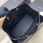 Structured black tote bag open to show inner lining and side pockets