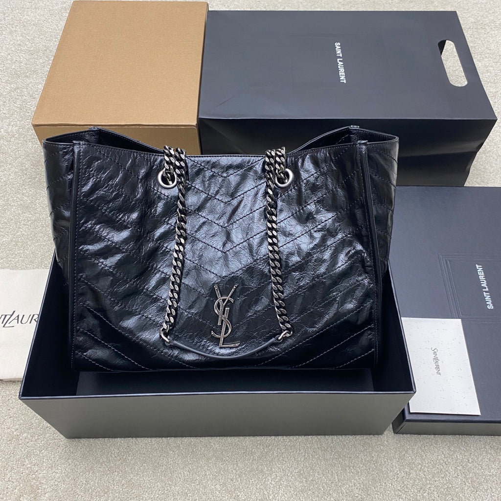 Quilted leather tote bag in dark black with chain straps and YSL logo charm