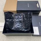 Quilted black tote bag with chain handles and YSL logo at the center