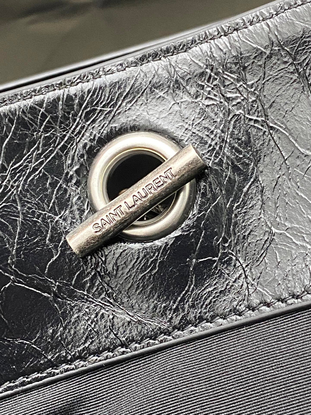 Black leather bag O-ring hardware with Saint Laurent fabric tag