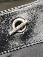 Black leather bag O-ring hardware with Saint Laurent fabric tag