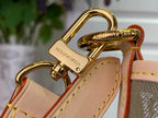 Gold-tone clasp on tan leather bag strap with monogram-style engraving