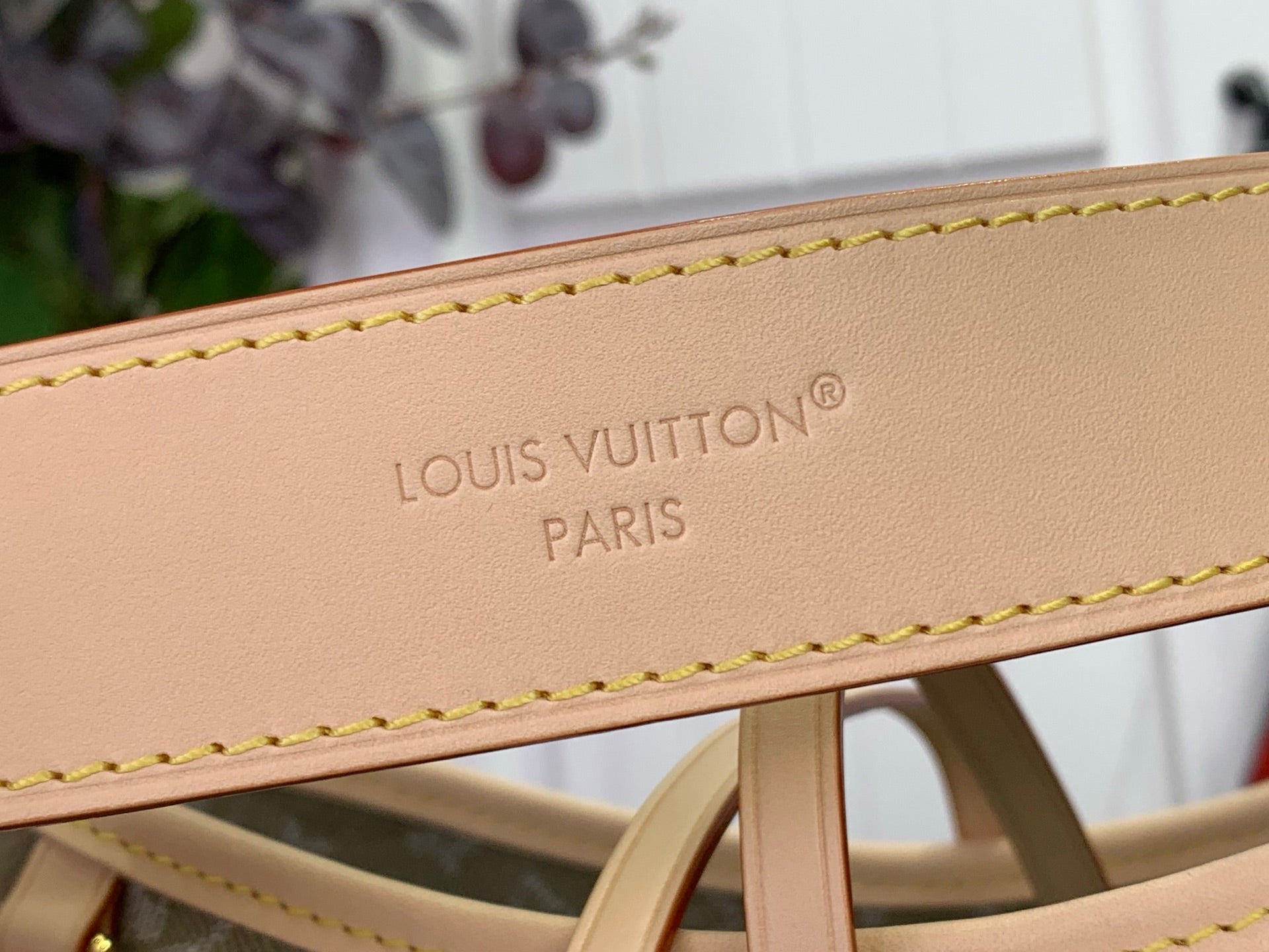 Tan leather strap with embossed LOUIS VUITTON PARIS lettering and stitching