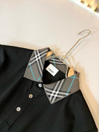 Black polo shirt neckline with plaid trim and button placket