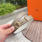 Hermes belt showing gold-tone buckle with chain, taupe strap