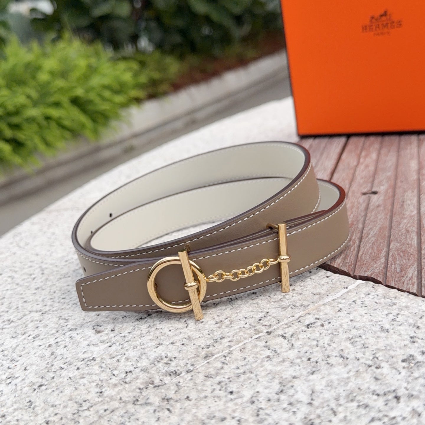 Hermes belt with taupe leather strap, gold buckle, and stitched edge