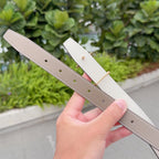 Taupe leather belt with gold buckle; punched holes on strap