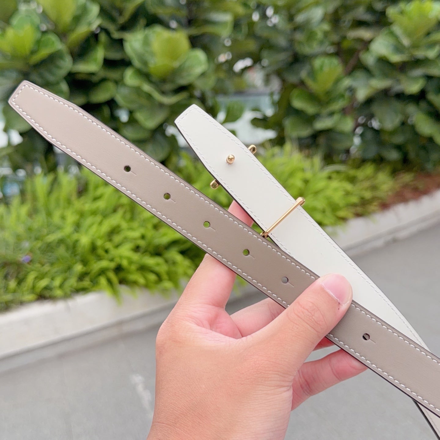Taupe leather belt with gold buckle; punched holes on strap