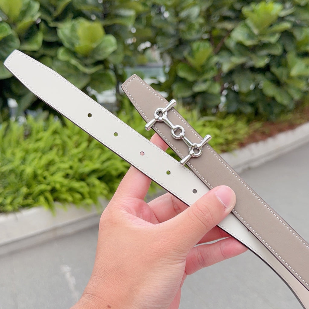 Hermes belt with light tan leather strap and silver buckle, showing strap holes