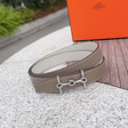 Hermes belt with light tan leather strap and silver buckle detail, shown in profile