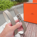 Hermes belt with light tan leather strap and silver buckle clasp, angled close-up