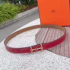 Hermes leather belt, red strap with tan lining and gold-tone double-ring clasp.