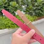 Hermes belt underside, tan leather strip with red strap holes and stitched trim.
