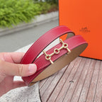 Hermes leather belt close-up, red leather strap with gold-tone buckle and tan lining.