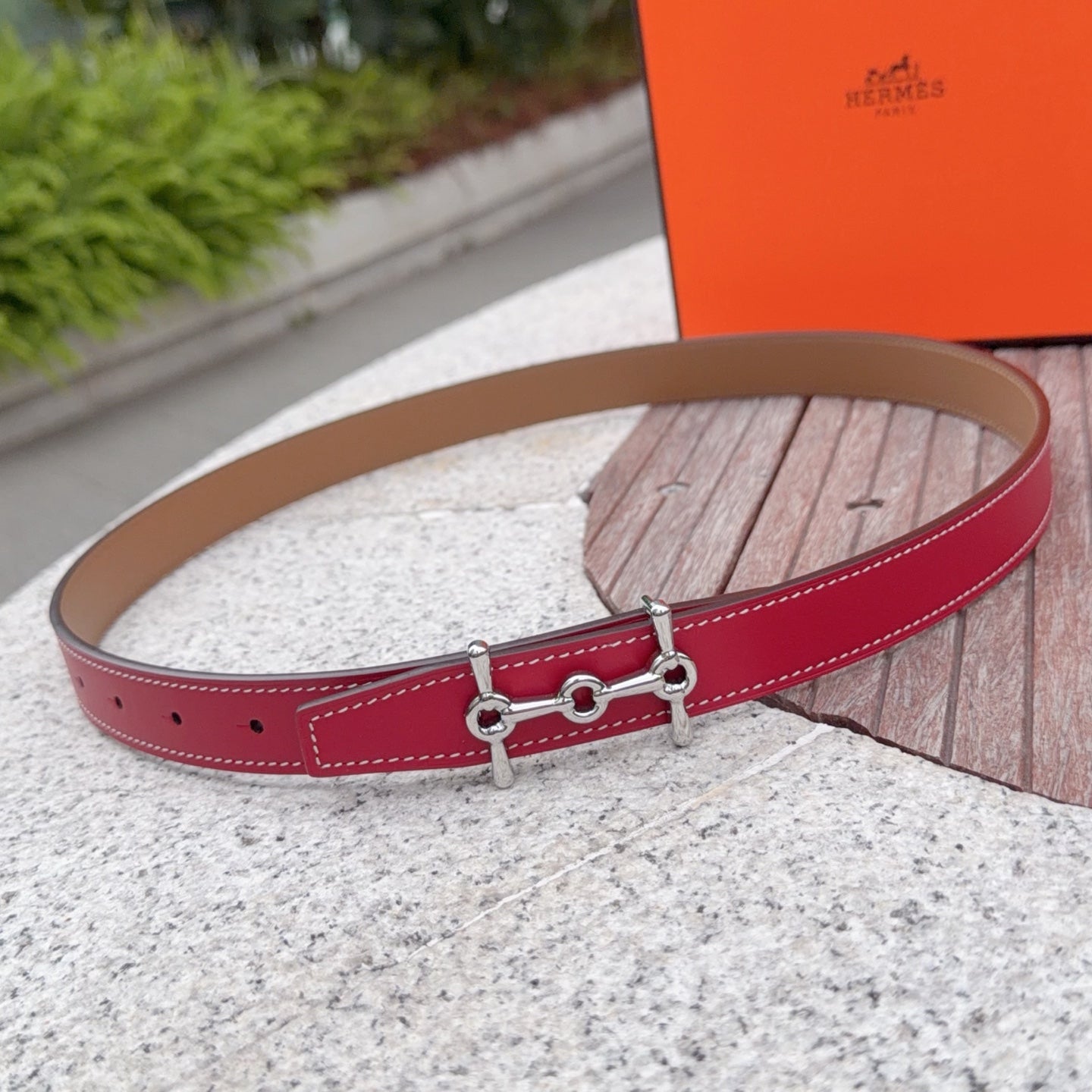 Red leather belt with tan underside, silver-tone buckle and double-ring detail