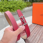 Red leather belt strap with silver buckle hardware and tan underside, hand-held