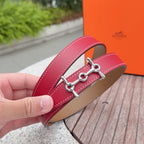 Red leather belt strap with silver buckle and tan interior, close-up in hand