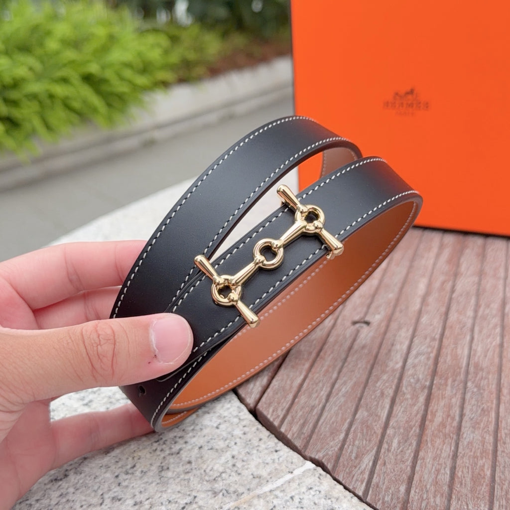 Hermes navy leather belt with gold-tone buckle, held in hand and stitched edges