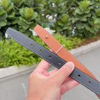 Two Hermes belts: dark and orange-brown leather straps with silver buckle hardware.