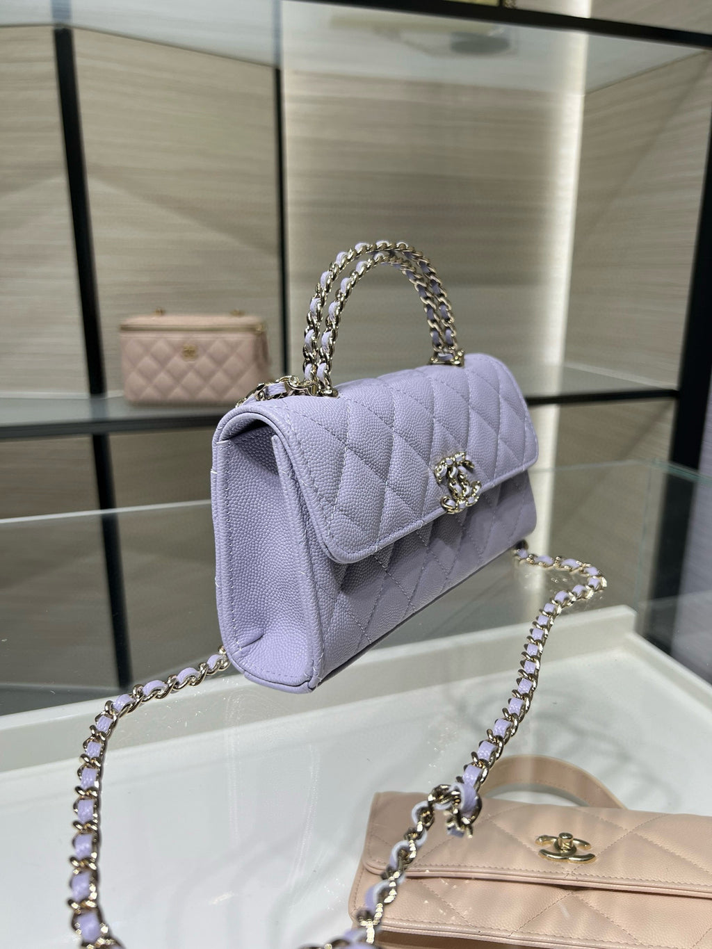 Lavender quilted mini handbag with curved flap and silver chain shoulder strap