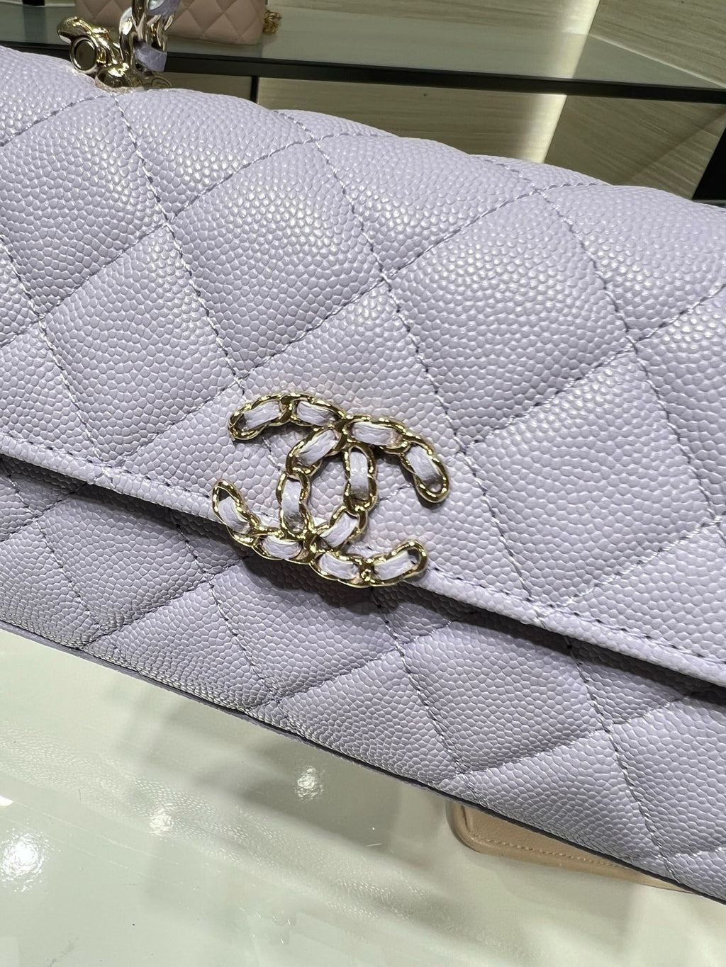 Lavender quilted handbag flap with gold CC-style metal clasp at center